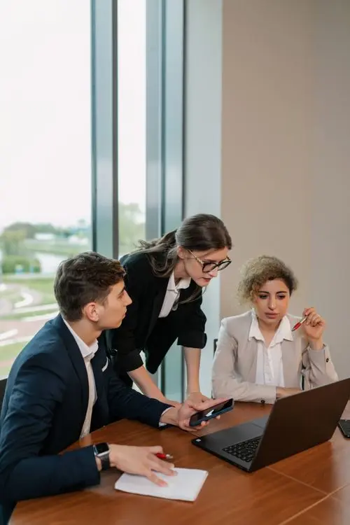 Business team reviewing work on a laptop by the window