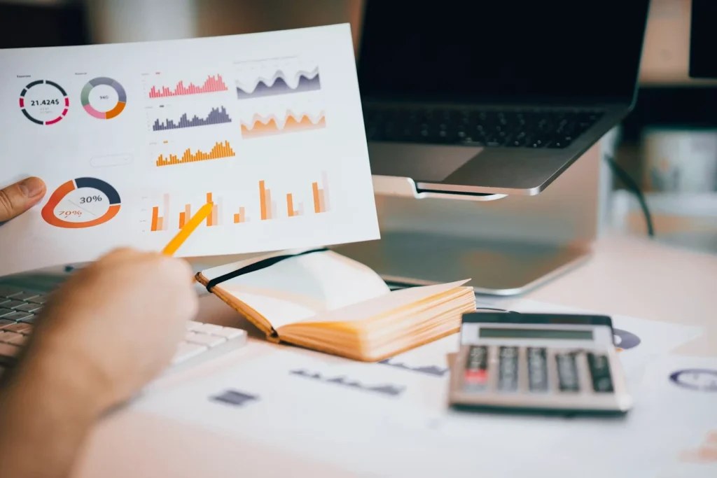 Financial charts and reports on a desk with a calculator