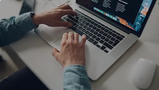 Hands typing on a laptop