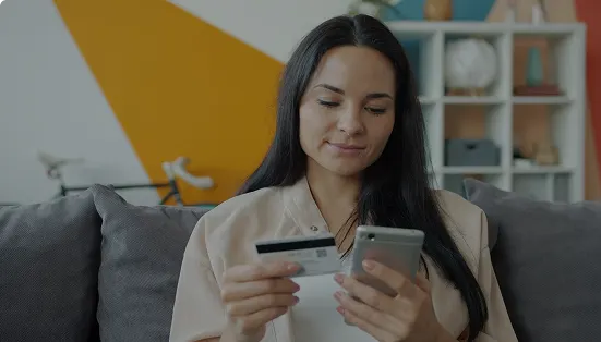 Woman paying online with a card and phone