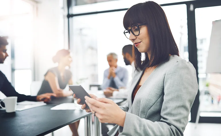 businesswoman using smartphone at meeting with col