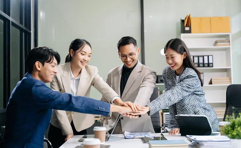 enthusiastic business team hands together in office
