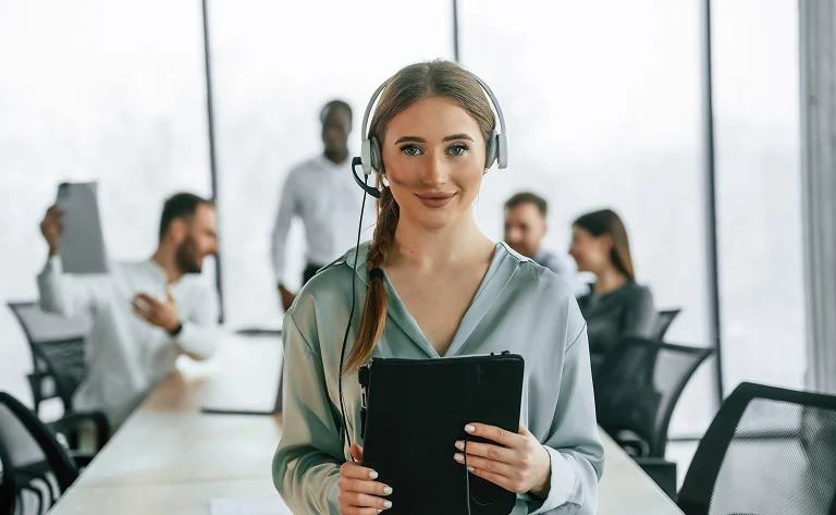 friendly woman with headset working in modern office