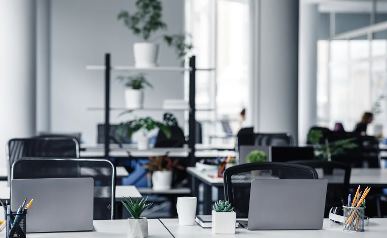modern office interior with desks and open laptops