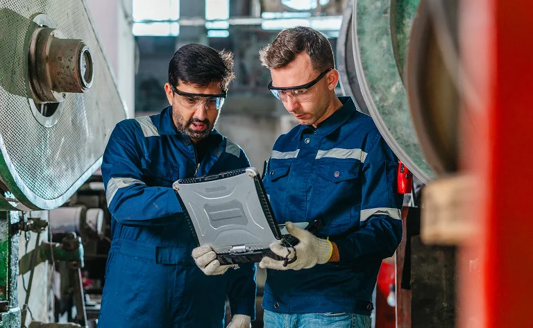two male industrial workers using a rugged tablet
