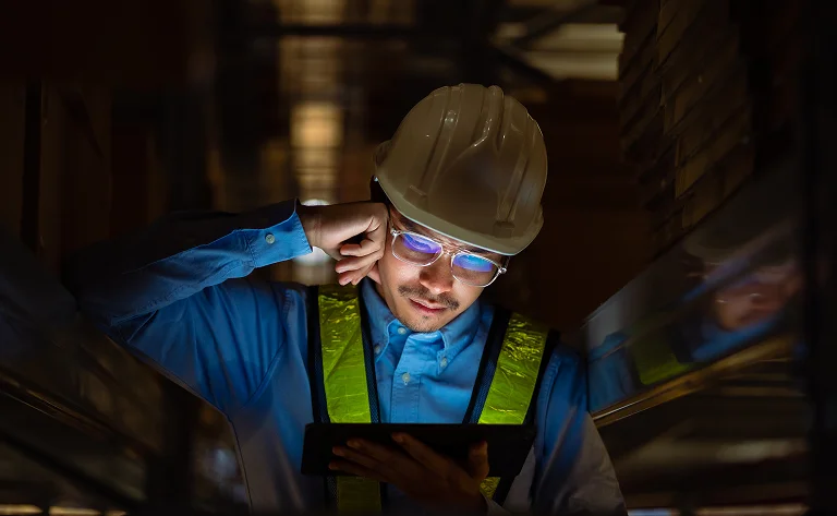 worker inspecting materials in factory with tablet