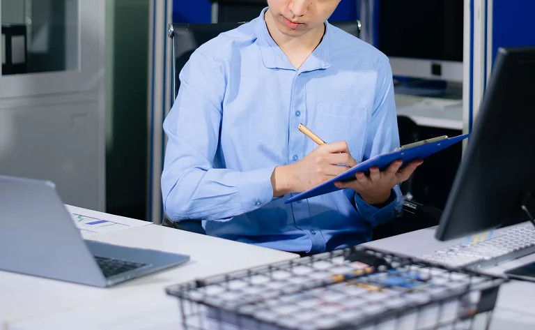 young-professional-man-writing on clipboard at mod